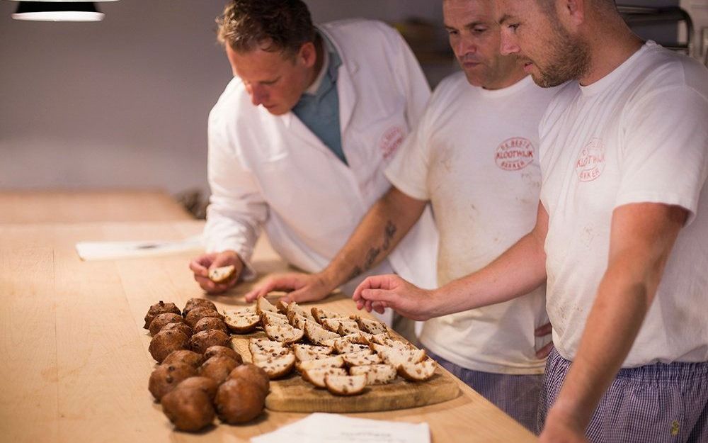 Jan Verwijs (rechts) met twee anders keurmeesters beoordelen de kwaliteit van oliebollen. beeld Bakker Klootwijk