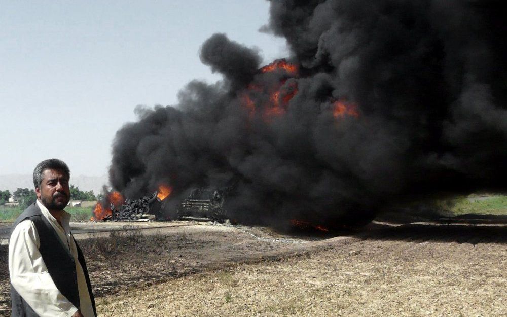 Afghanen gooien olie naar NAVO-troepen.  Foto EPA