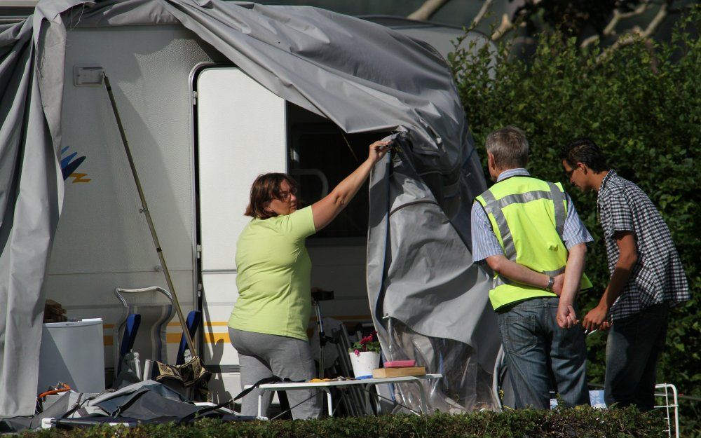 Gasten van camping Kemperplas in het Gelderse Vethuizen ruimen donderdag hun caravan op. Foto ANP