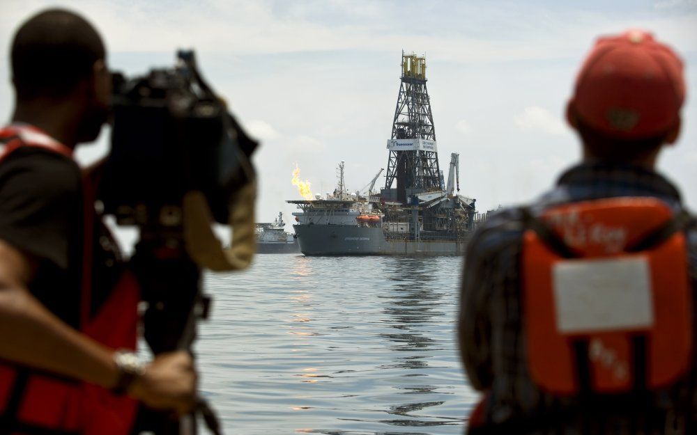 Een televisieploeg filmt de Discoverer Enterprise. Deze fakkelt gas af en vangt olie op uit het lek van het gezonken olieplatform Deepwater Horizon, 10 juli. Foto ANP