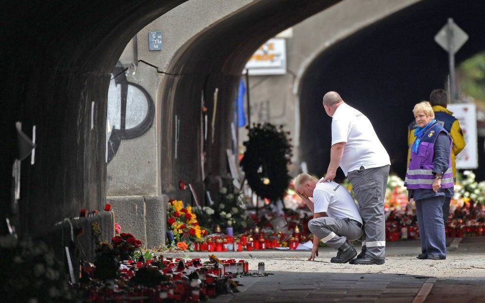 Rouwenden bij de tunnel waar het drama tijdens de Loveparade plaats vond. Foto EPA