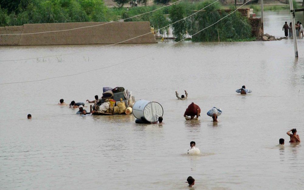 Pakistanen vluchten voor het wassende water. Foto EPA