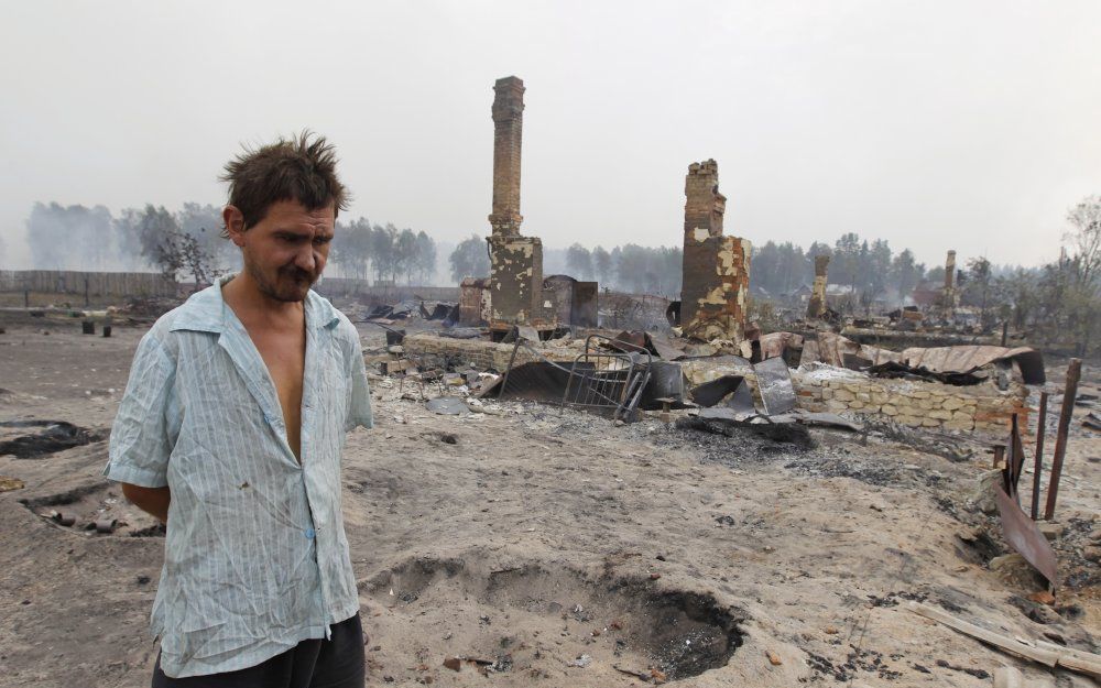 Een Rus treurt bij zijn afgebrande huis. Foto EPA