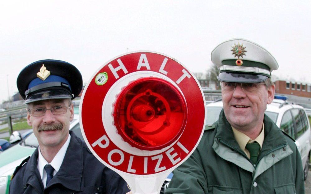 Als deze Nederlandse (l.) en Duitse (r.) agenten elkaar over een paar jaar weer treffen, is de kans groot dat ze beiden een blauw uniform dragen. Duitsland volgt de Europese standaard. Foto EPA