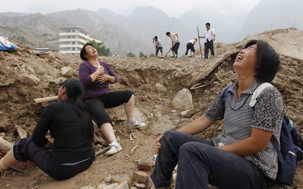 Vrouwen treuren om het verlies van geliefden na de aardverschuiving in de provincie Gansu. Foto EPA