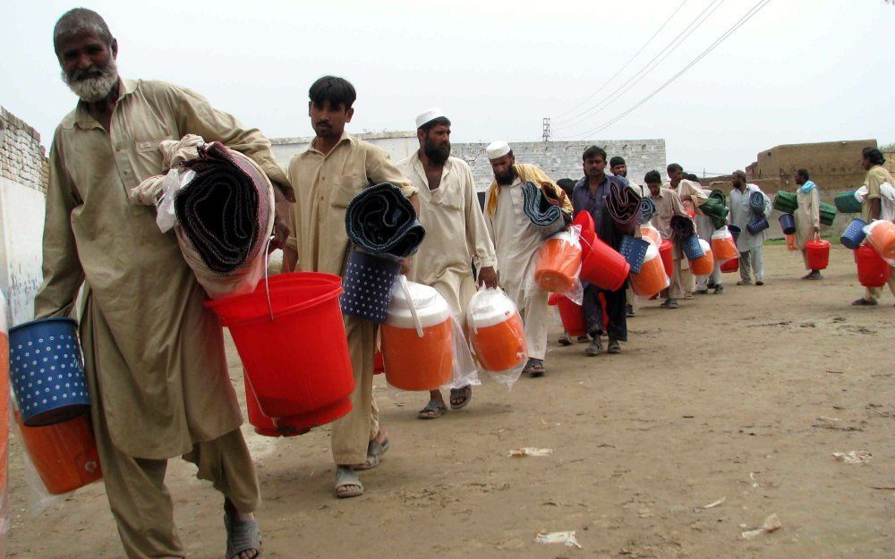 Gevluchte Pakistanen ontvangen hulpgoederen. Foto EPA