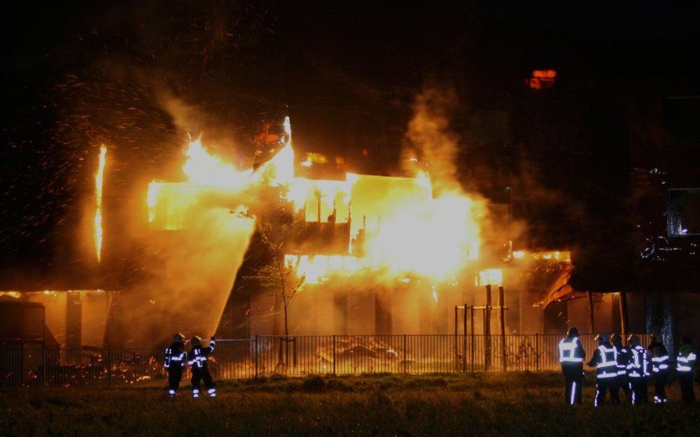 Brandweerlieden proberen zaterdag een grote brand in basisscholen De Hoeksteen de De Vlint onder controle te krijgen. Foto ANP