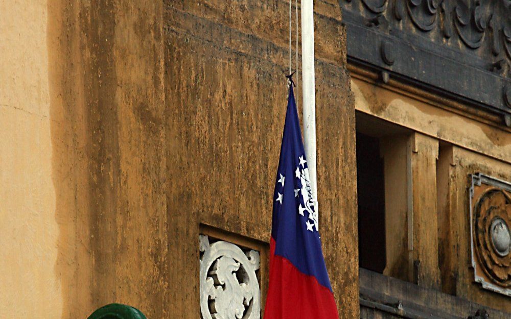 De oude vlag van Myanmar wordt gestreken op het stadhuis van de hoofdstad Yangon. Foto EPA