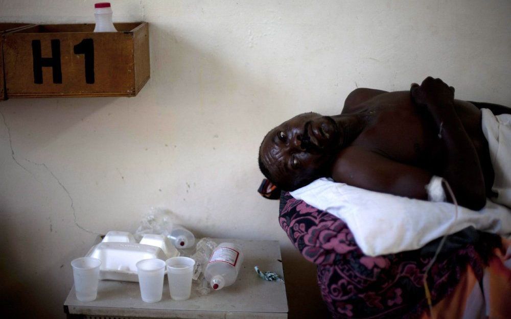 Een cholera-patiënt ligt op bed in een dorpje langs de rivier Artibonite. Foto EPA