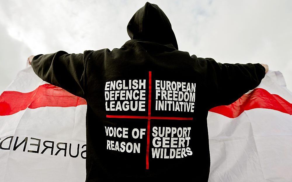 Leden van de English Defence League tonen zaterdag een vlag aan de media. Een kleine groep demonstranten van de extremistische English Defence League heeft zaterdagmiddag zijn steun betuigd aan Geert Wilders. Foto ANP