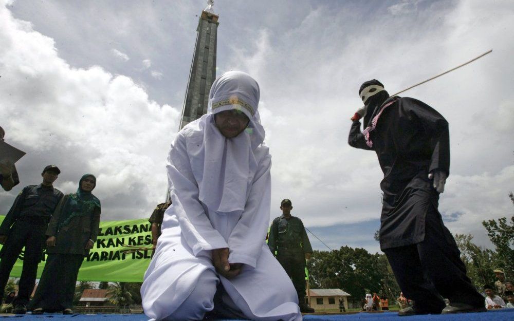 BANDA ATJEH – Murni binti Anisa, een Atjehse vrouw, werd op 1 oktober publiekelijk met stokslagen gestraft omdat ze de sharia had overtreden. Ze had tijdens de ramadan op straat eten verkocht. Foto EPA