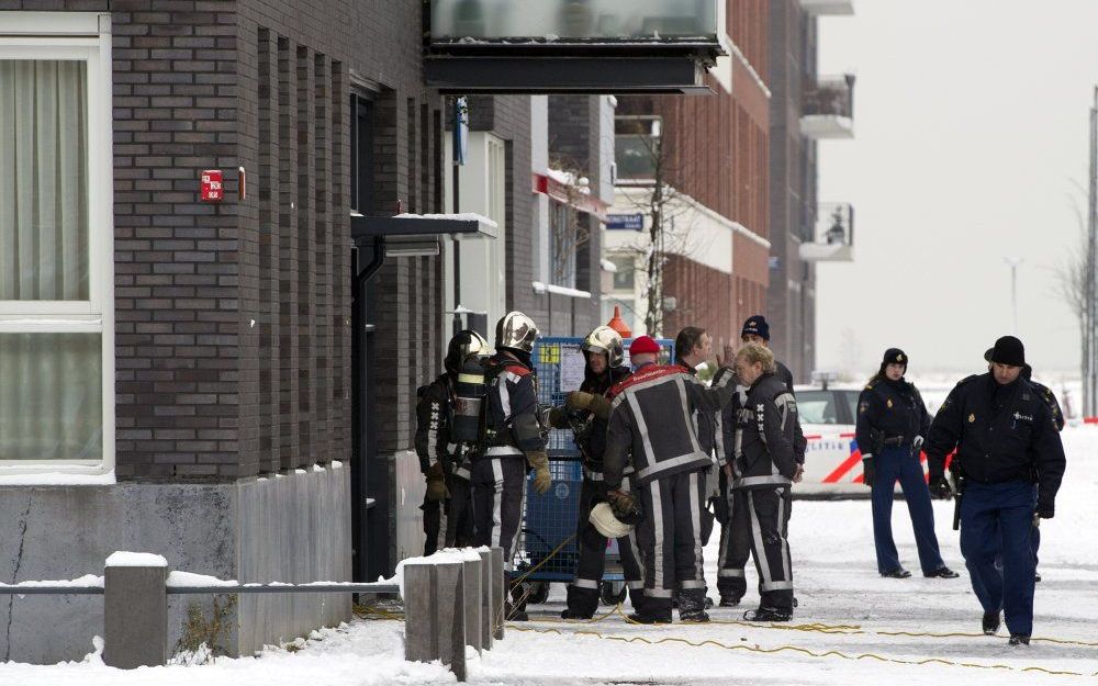 Brandweerlieden staan zaterdag klaar bij een ondergrondse parkeergarage in de Amsterdamse wijk IJburg. Foto ANP