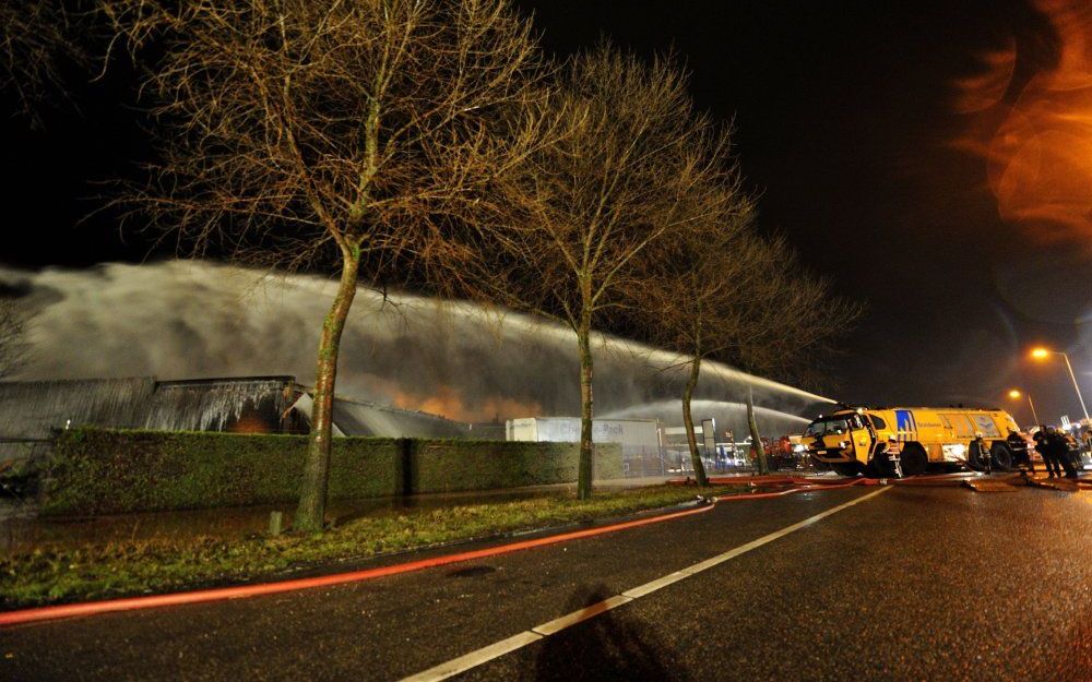 Met een zogenaamde crashtender wordt een deken van schuim gespoten over de brand bij chemisch bedrijf Chemie-Pack op het industrieterrein aan de Vlasweg in Moerdijk. Foto ANP