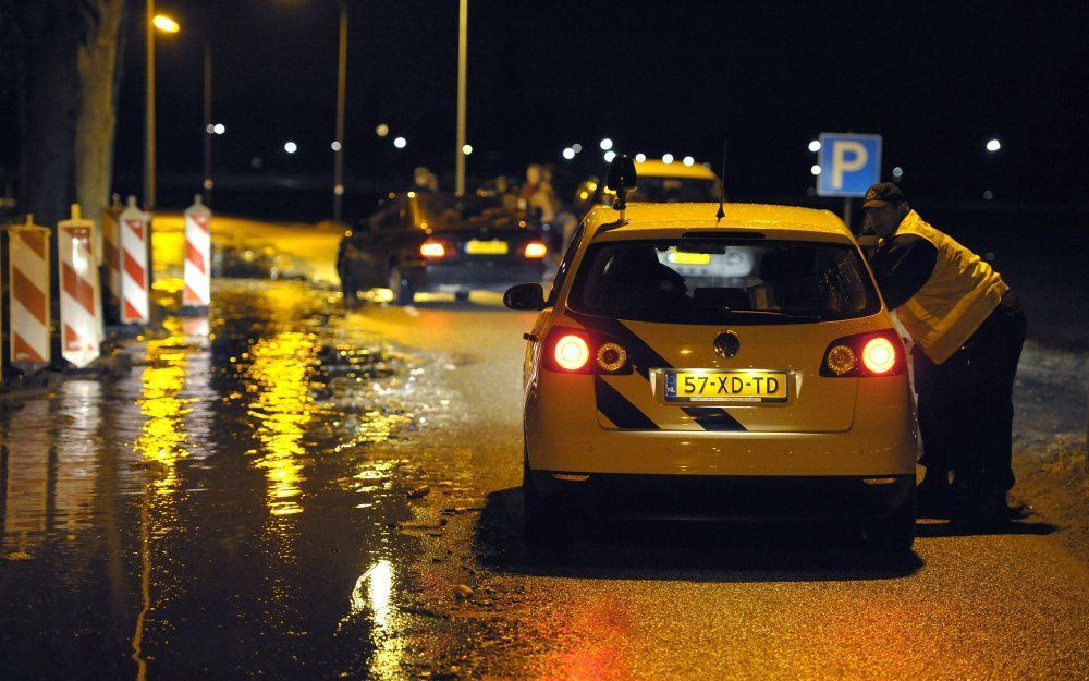 In de loop van de nacht werden de toegangswegen naar de dorpen Itteren en Borgharen afgesloten vanwege het hoge water. Foto ANP