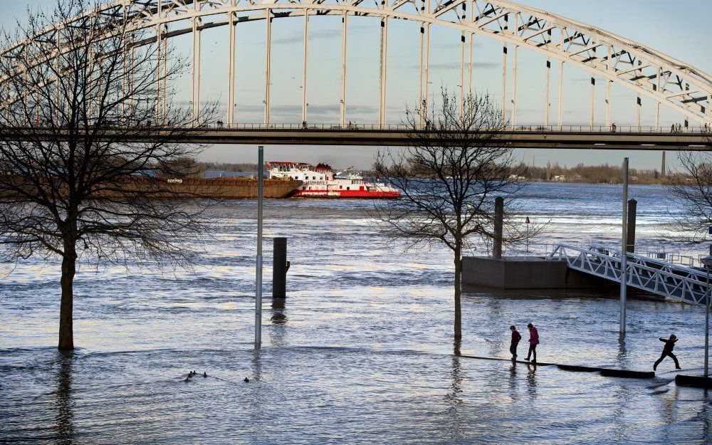 Kinderen spelen op de ondergelopen Waalkade in Nijmegen. Foto ANP