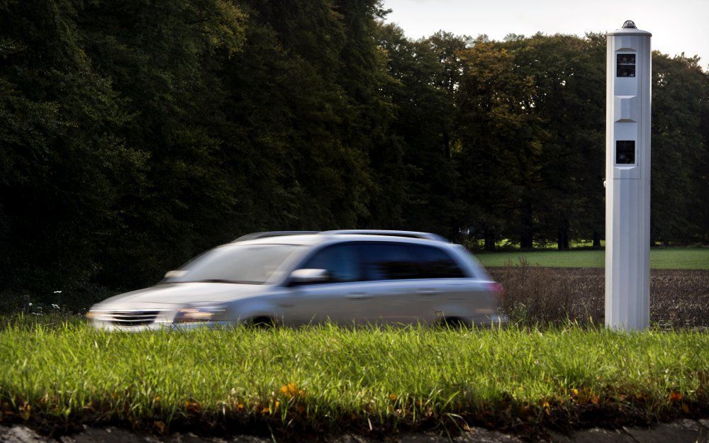 Auto rijdt langs digitale flitspaal. Foto ANP