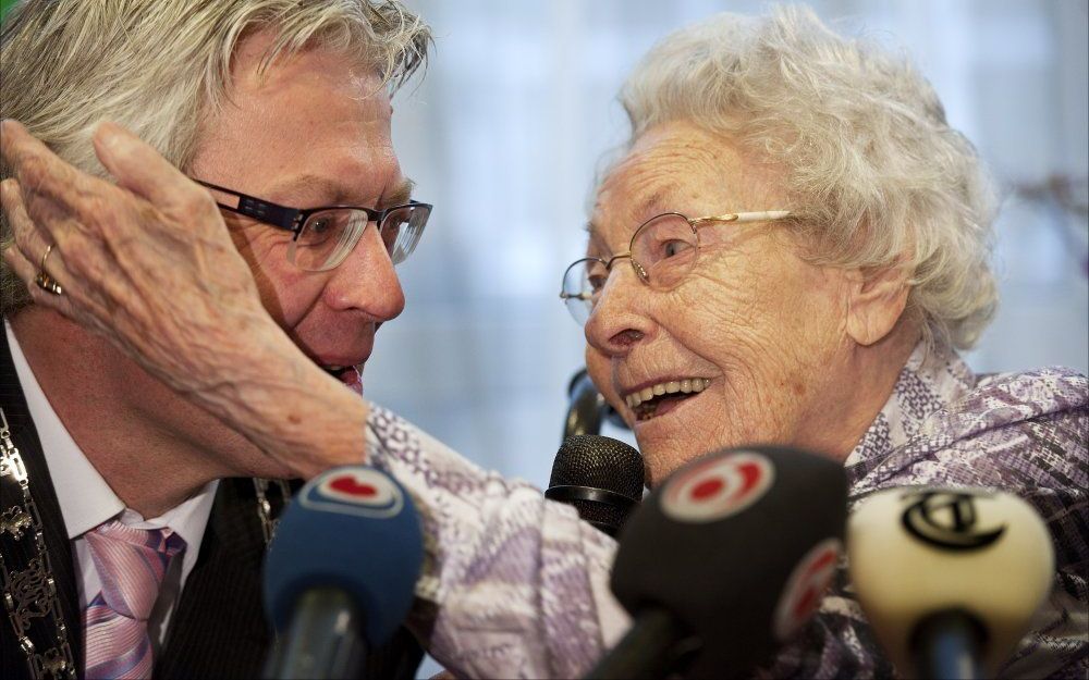 Omringd door camera’s en journalisten gaf de oudste vrouw van Nederland een soort ‘persconferentie’. Burgemeester Crone van Leeuwarden (l.) en de Friese lococommissaris van de Koningin, Galema, kwamen de 109-jarige Geertruida Draaisma uit Leeuwarden perso