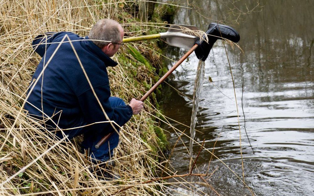 Een forensisch rechercheur vist dinsdag in Woudenberg een lederen dameslaars uit een beek in de omgeving waar Sandra Hazeleger, een telg uit een van de rijkste families van Nederland, dinsdagmorgen dood werd gevonden. Foto ANP