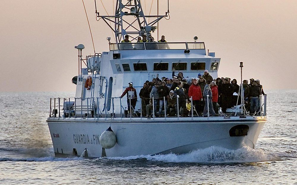 Italiaanse agenten brengen Noord-Afrikaanse immigranten naar het eiland Lampedusa. Foto EPA