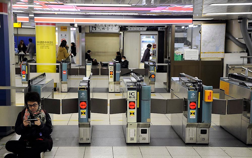 Reizigers zitten tijdens aardbeving op de grond in station Tokio. Foto EPA