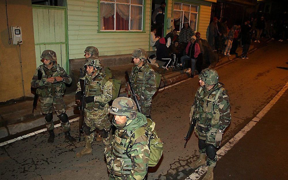 Na de evacuatie vanwege het dreigende tsunami gevaar patrouilleren soldaten door de straten van Talcahuano in Chili.  Foto EPA