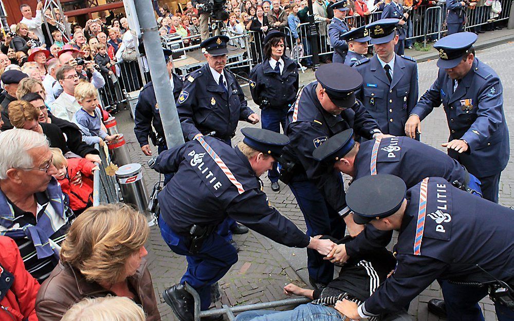 De man die tijdens Prinsjesdag een waxinelichtje naar de Gouden Koets heeft gegooid werd direct aangehouden door de politie. Foto ANP