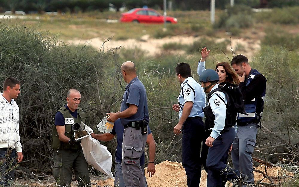 Israëlische bomexperts onderzoeken de resten van een Gradraket. Foto EPA