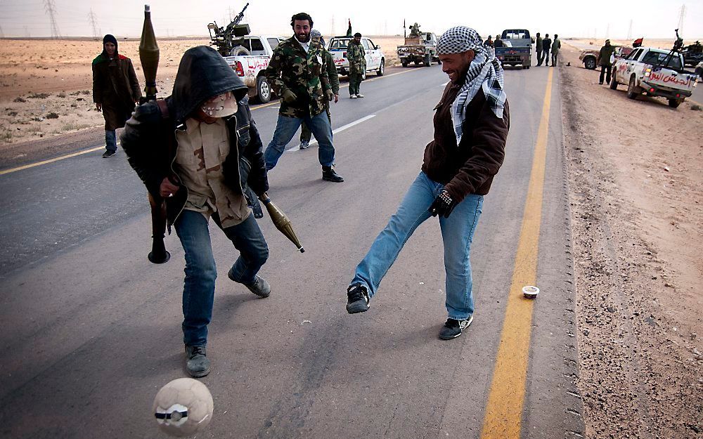 Libische opstandelingen spelen een potje voetbal op een weg nabij de oostelijke stad Ajdabiyah. Foto EPA