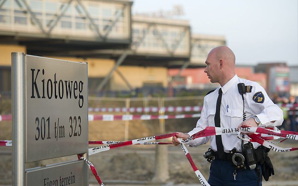 Een politieagent zet maandag het terrein rond het waardetransportbedrijf SecurCash aan de Kiotoweg in Rotterdam af.  Foto ANP