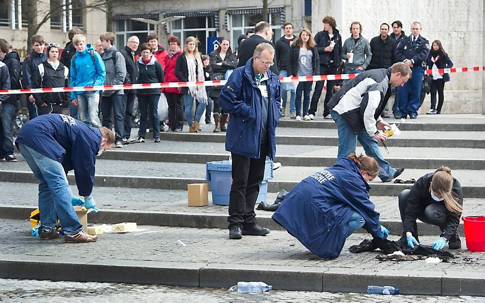 Medewerkers van de technische recherche onderzoeken woensdag de afgezette plek op de Dam in Amsterdam. Foto ANP