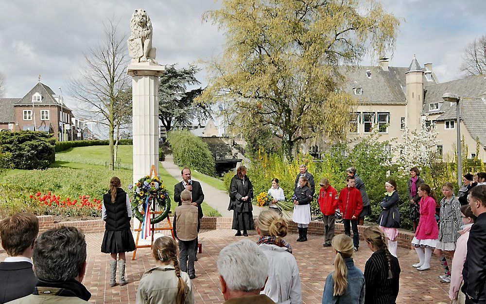 Leerlingen van de Ds. Johannes Beukelmanschool in Alblasserdam op 21 april vorig jaar bij het oorlogsmonument in de Polderstraat. Foto Rob Kamminga