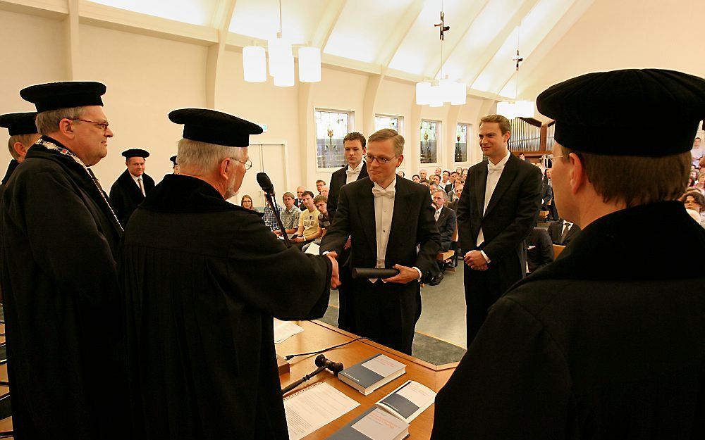 Uit handen van zijn promotor prof. dr. J. W. Maris ontving drs. A. Huijgen woensdag zijn doctorsbul. De Genemuider predikant onderzocht het begrip accommodatie bij Johannes Calvijn. Foto RD, Anton Dommerholt