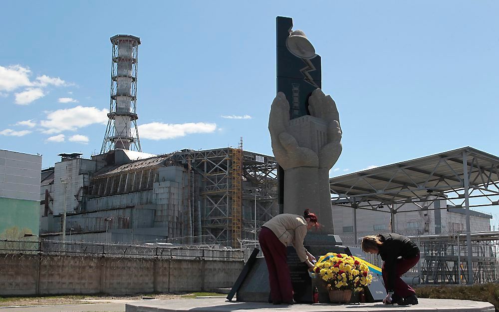 Vrouwen leggen een krans bij het monument nabij de kerncentrale van Tsjernobyl. Foto EPA