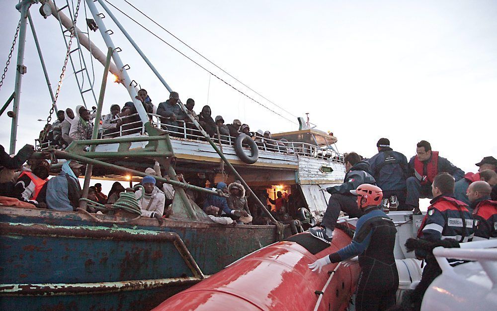 De Italiaanse kustwacht helpt een boot met Libische vluchtelingen. Foto EPA