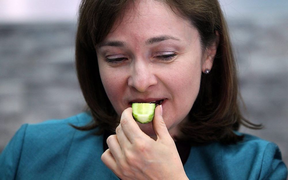 De Russische minister van Economische Ontwikkeling, Elvira Nabiullina, eet een komkommer van Russische bodem. Foto EPA