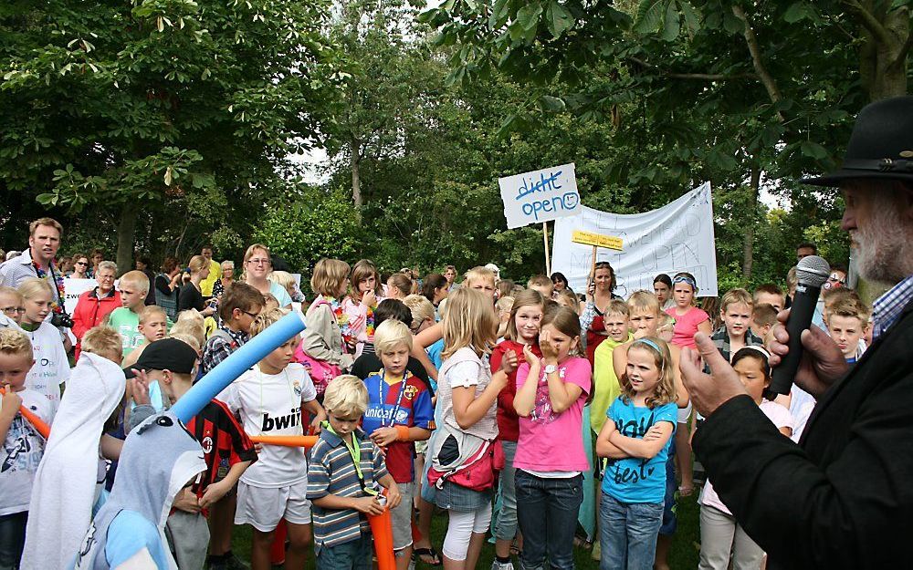 Leerlingen van alle vier de basisscholen uit Nieuw-Lekkerland overhandigden 1100 handtekeningen aan wethouder Hoogendoorn (r.). De scholieren willen dat zwembad Schoonenburg open blijft. Foto Werkorganisatie De Waard