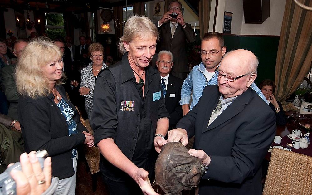 Zwier van der Weerd jr. overhandigde gisteren de vliegenierspet van piloot King Cole aan diens zoon, Alistair.	Foto Ruben Meijerink