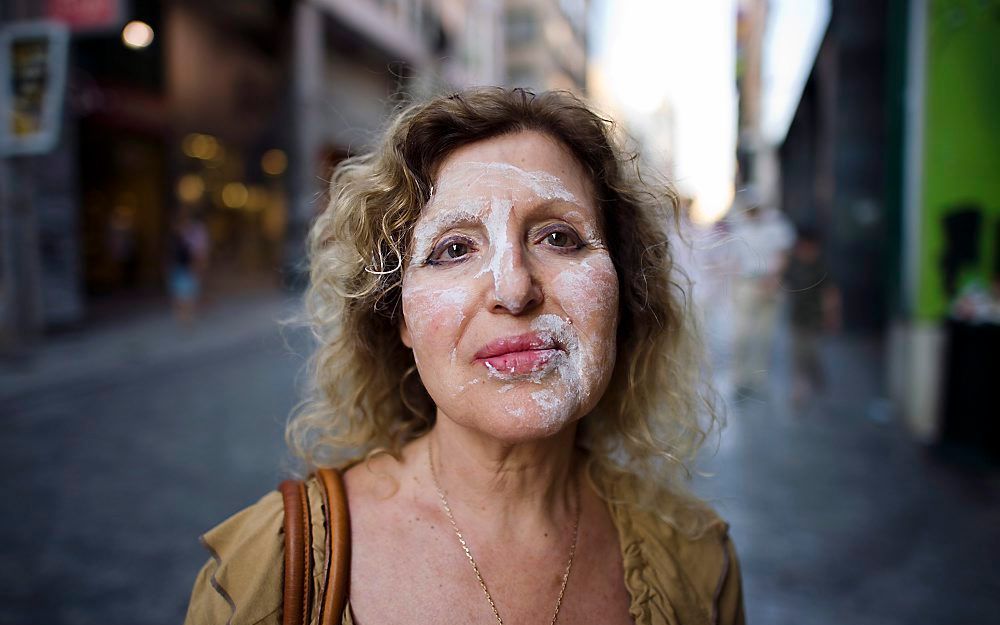 Een Griekse vrouw heeft traangas op haar gezicht. Foto EPA