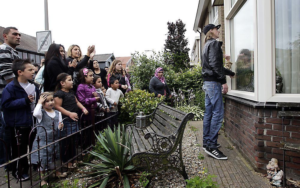 Een buurtbewoner klopt op het raam van het huis van het bestuurslid van pedovereniging Martijn tijdens de protestmars van Partij Rechten Kind. Foto ANP