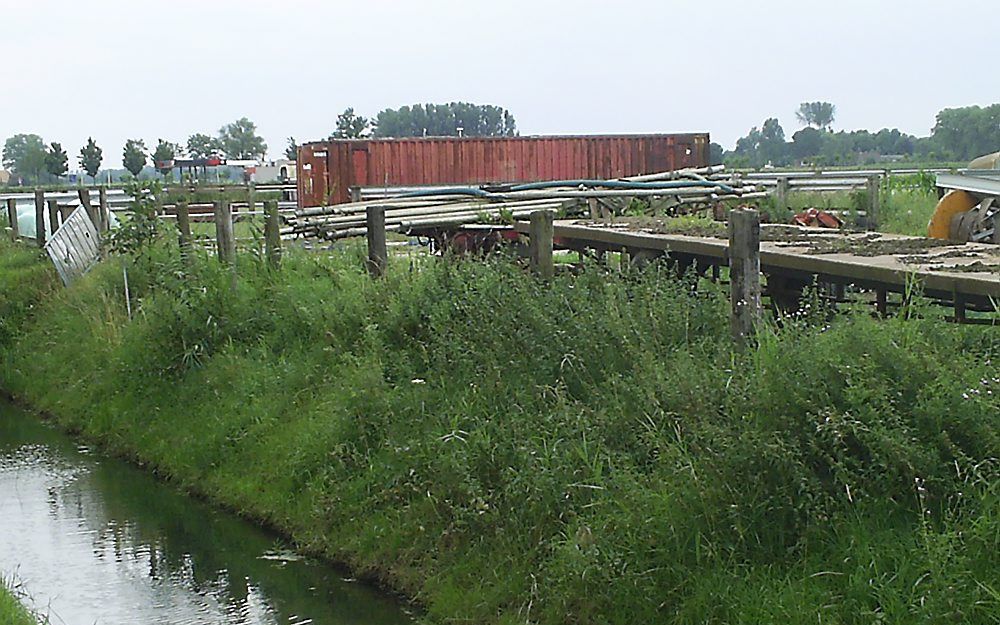 Spullen uit een loods van een agrariër uit Wijk en Aalburg in het weiland. De gemeente Aalburg wil de spullen verwijderen, maar gedoogt vooralsnog de situatie. Foto André Bijl