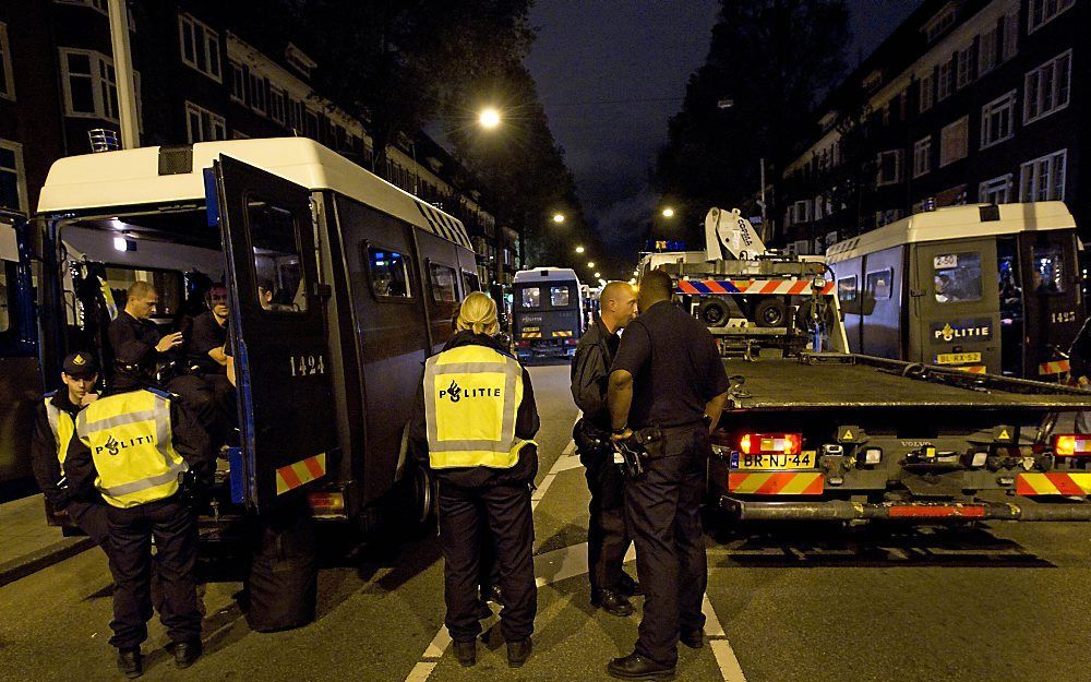 Politieagenten verzamelen zich zaterdagnacht in Amsterdam tijdens een controle van de Molukse motorclub Saturdarah. Er werden tientallen leden opgepakt. Foto ANP