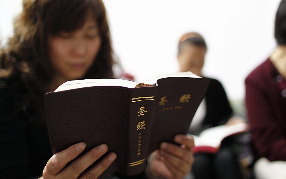 Een Chinese vrouw leest in haar Bijbel tijdens een samenkomst in een huiskerk. Het aantal christenen in China wordt geschat op ruim 100 miljoen. Foto EPA