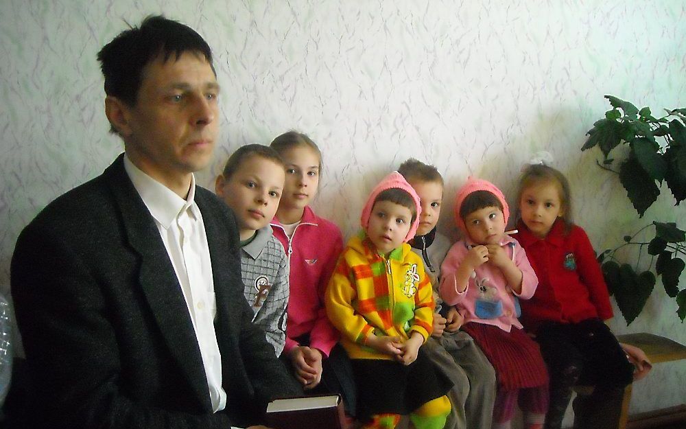 Een man met zijn kinderen in de kerk. Foto Anke van Vlastuin