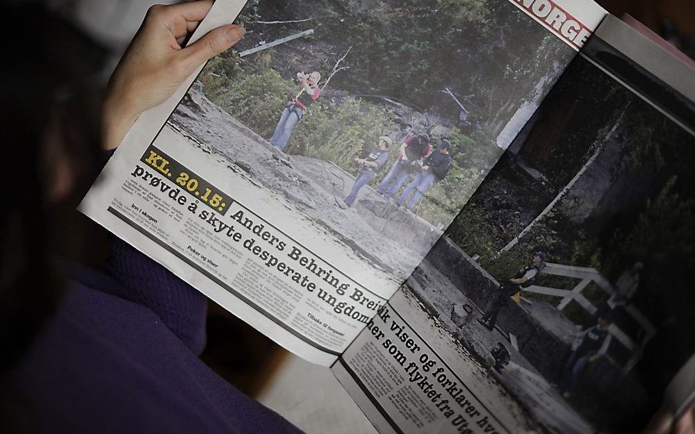 Een vrouw leest het blad The Verdens Gang (VG) met een foto van Anders Breivik, gehuld in een kogelvrij vest, op het Noorse eiland Utoya. De foto is zaterdag gemaakt tijdens een reconstructie van het bloedbad dat in juli op het eiland plaatsvond. Foto AFP