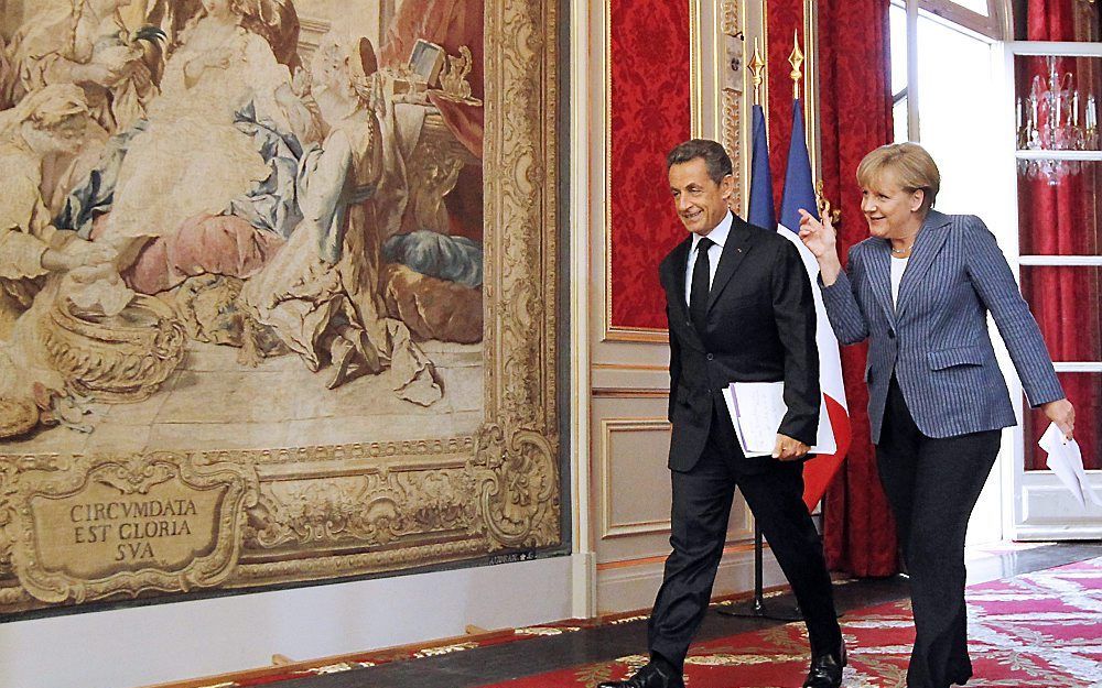 Merkel en Sarkozy op weg naar een persconferentie, dinsdagavond. Foto EPA