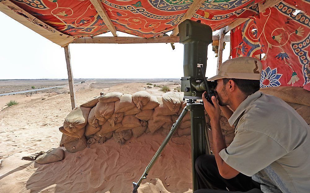 Een rebel houdt de wacht tussen de Libische steden Misurata en Bani Walid. Foto EPA