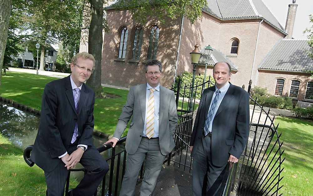 Drs. Van Hartingsveldt, ir. Murre en ds. Van Den Belt (v.l.n.r.) voor de hervormde dorpskerk van Woudenberg. Foto RD, Anton Dommerholt