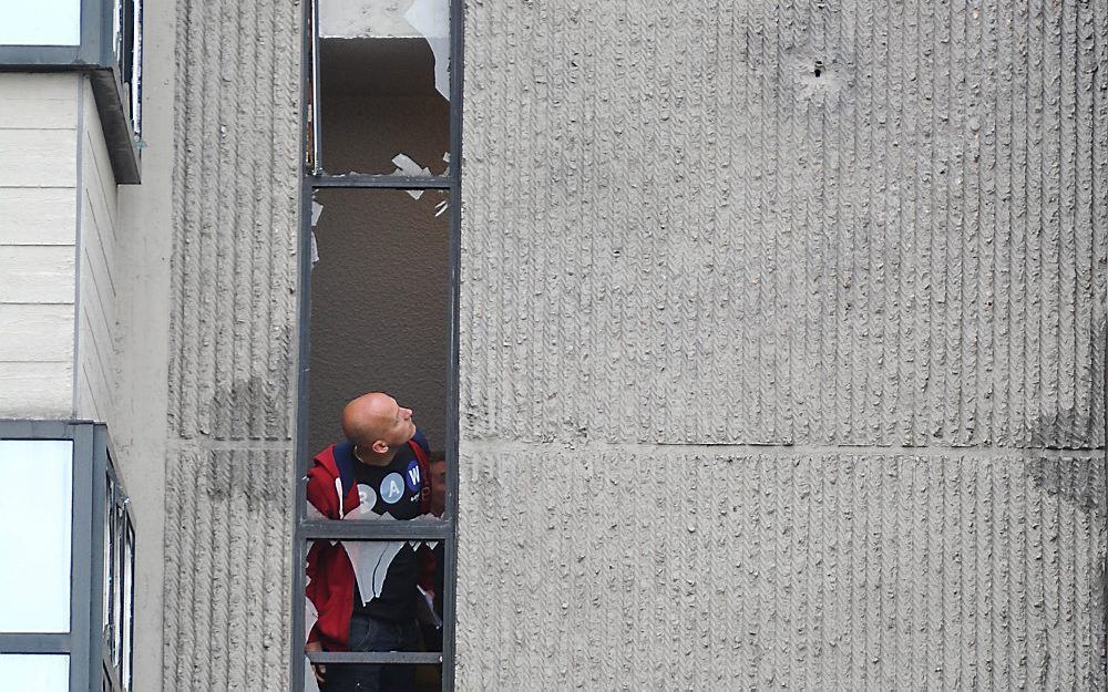 Een man bekijkt woensdag de zware beschadigingen aan Toren E van de rechtbank aan de Parnassusweg in Amsterdam. Foto ANP