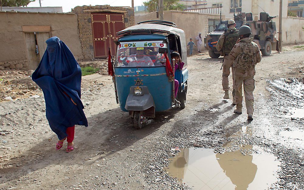 Nederlandse militairen brengen een bezoek aan een politiepost in Kunduz.  Foto ANP