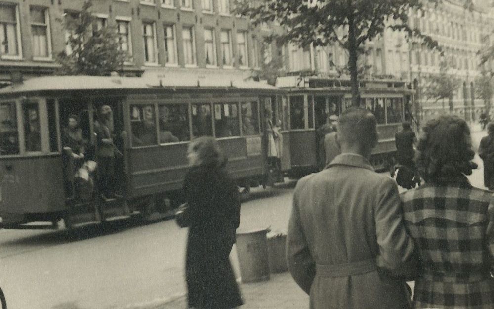 AMSTERDAM – Een tram vol opgepakte Joden rijdt op klaarlichte dag door de Amsterdamse Wijttenbachstraat, april 1943. Voorbijgangers kijken toe. Foto Karel Bönnekamp